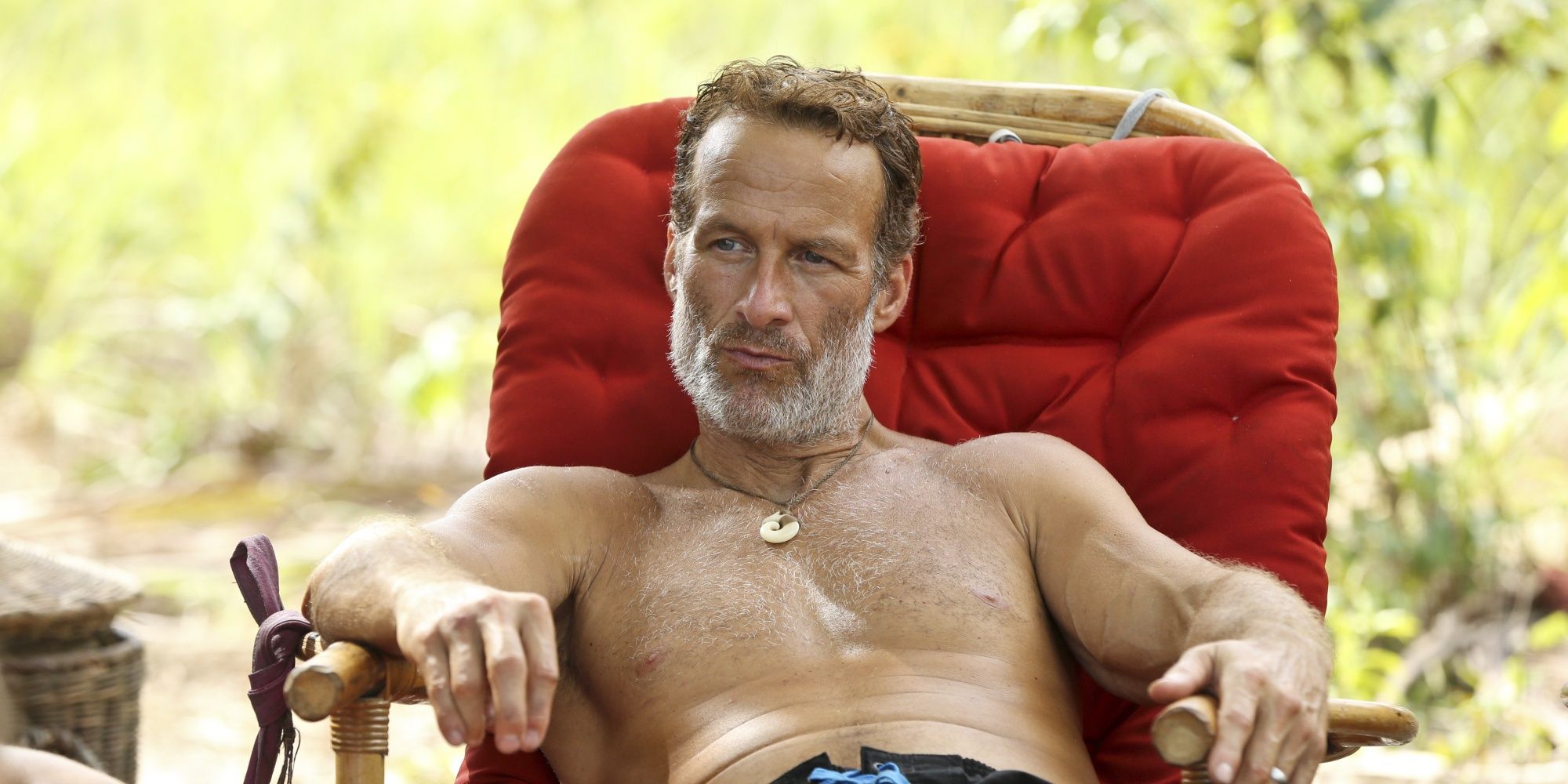 Andrew Savage lounging in a chair in Survivor