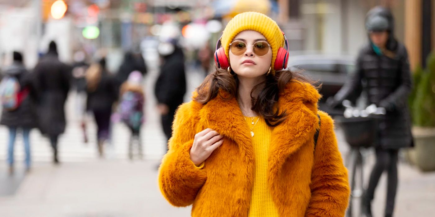 Mabel walking down the street wearing headphones in Only Murders In The Building