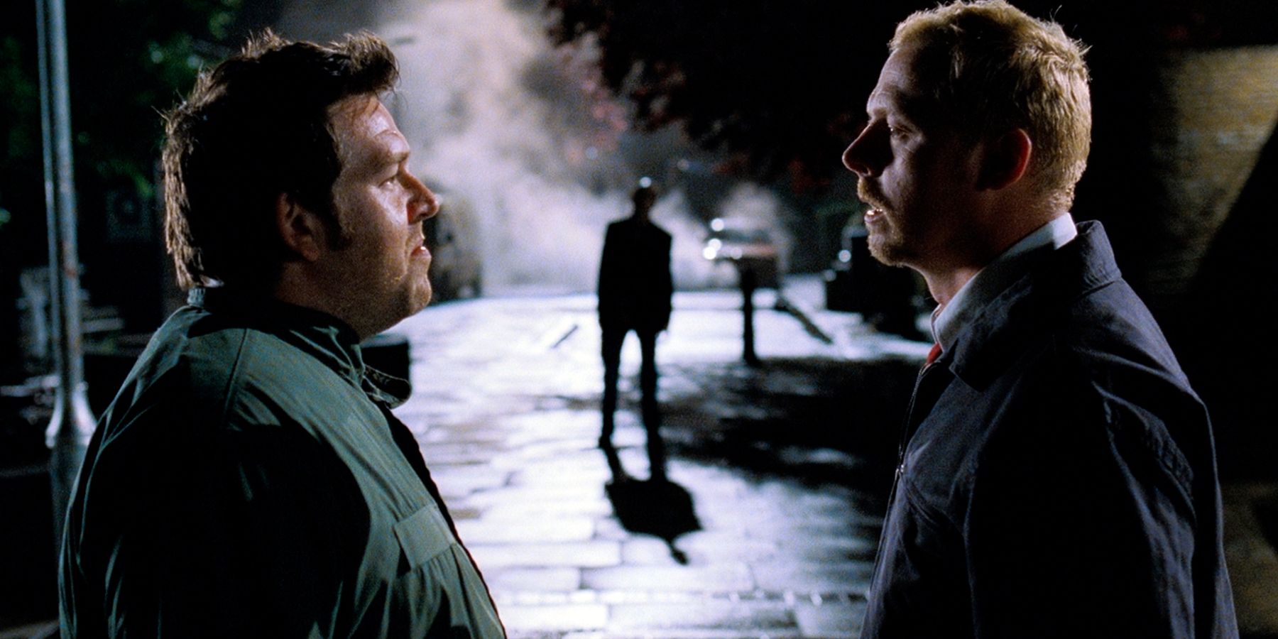 Shaun &amp; Ed talk to each other with a zombie in the background in Shaun of the Dead.