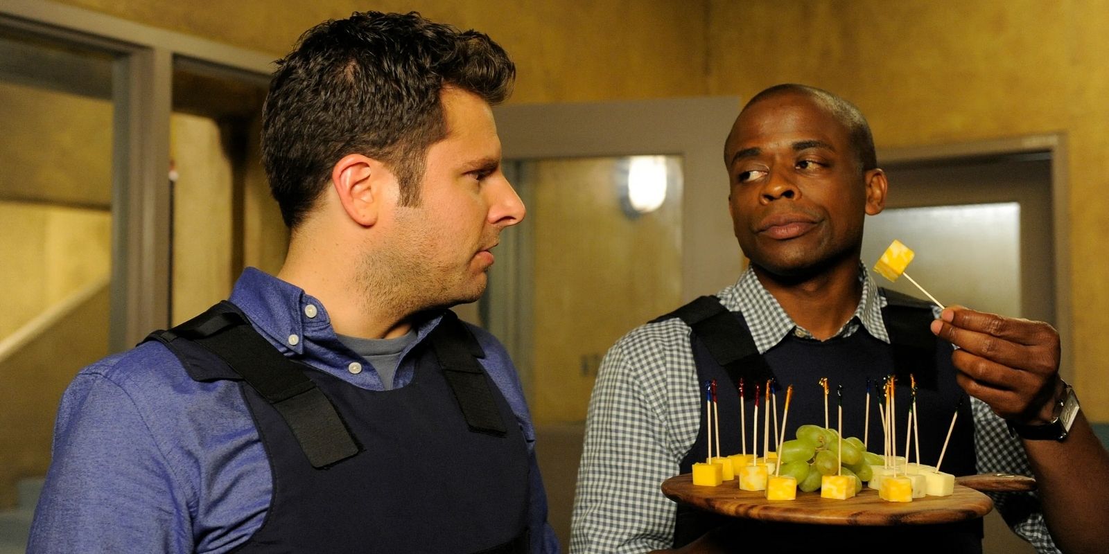 Shawn Spencer and Burton Guster hold a tray of cheese in Psych.
