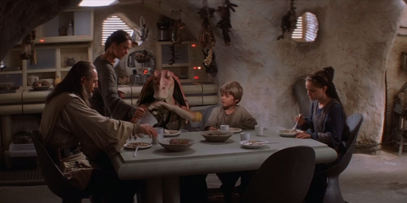 Shmi Skywalker feeds dinner to Qui-Gon, Jar Jar, Anakin, and Padmé in their home in The Phantom Menace.