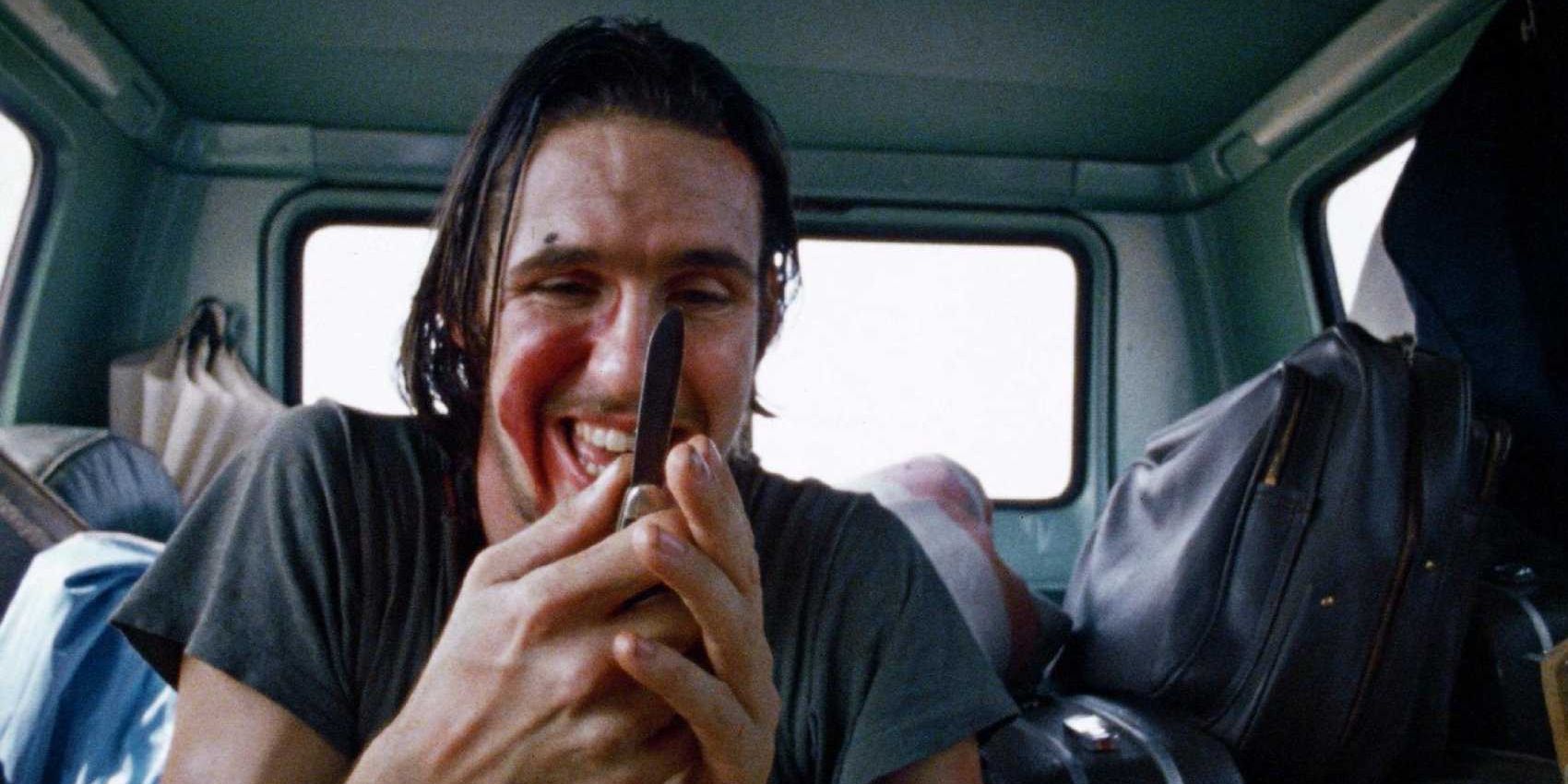 The hitchhiker from The Texas Chainsaw Massacre holding a knife.