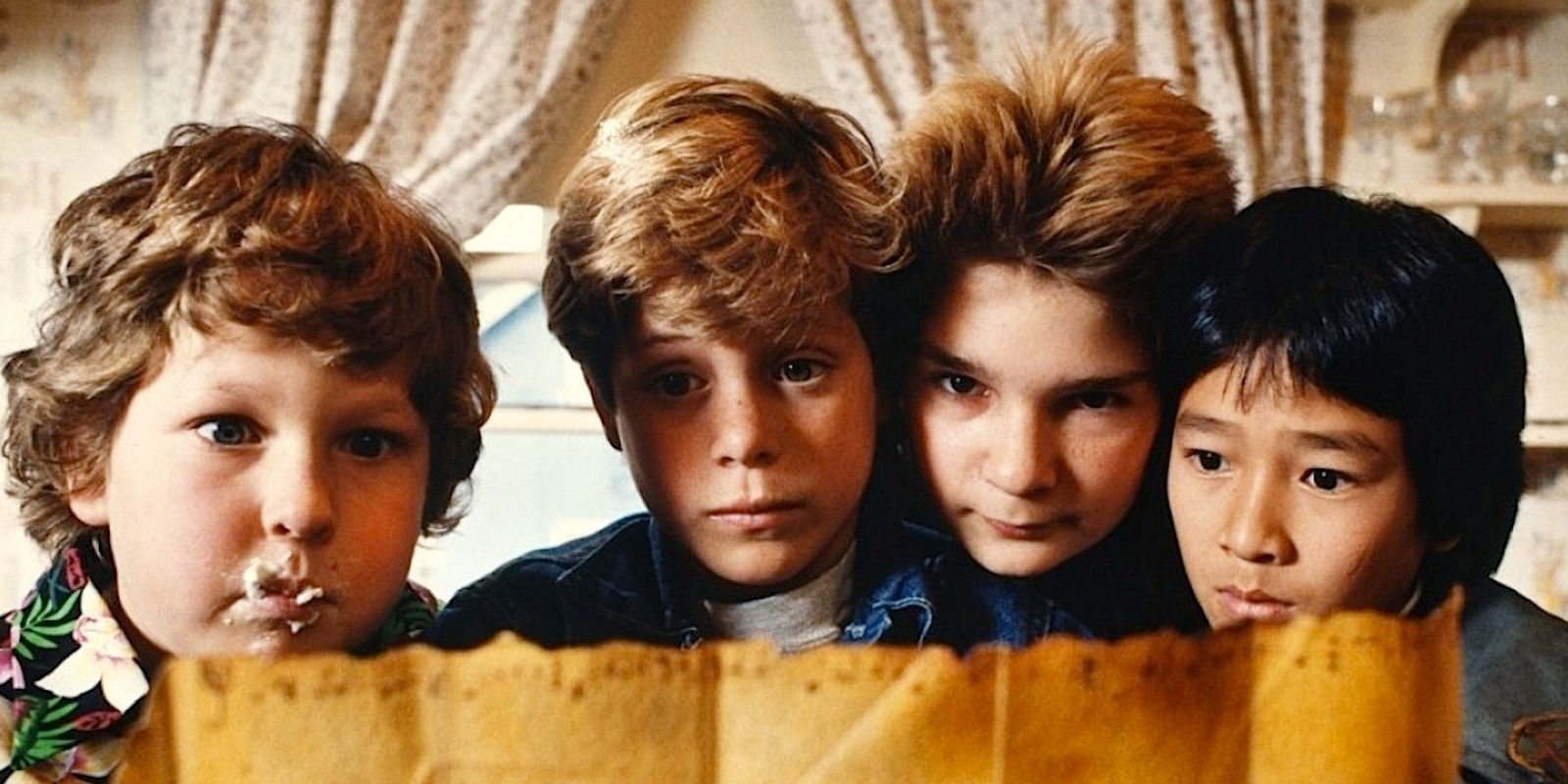 The cast from The Goonies looking at a map