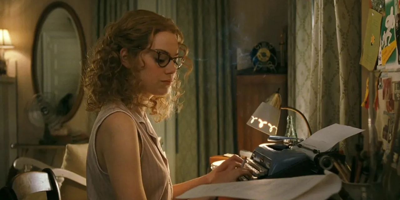 Emma Stone types on a typewriter at night in The Help.