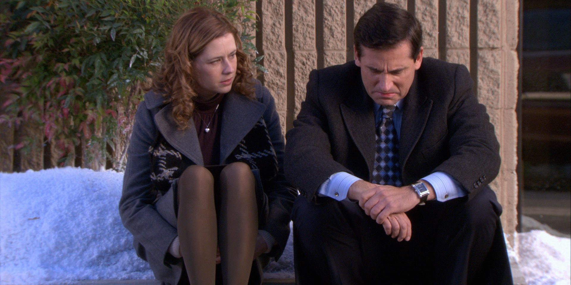 Pam sits with a dejected Michael Scott on a curb in The Office.