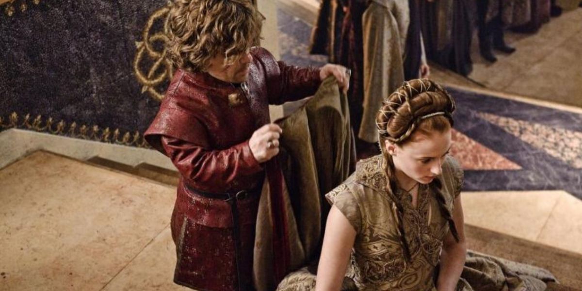 Tyrion cloaks a kneeling Sansa during their wedding in Game of Thrones