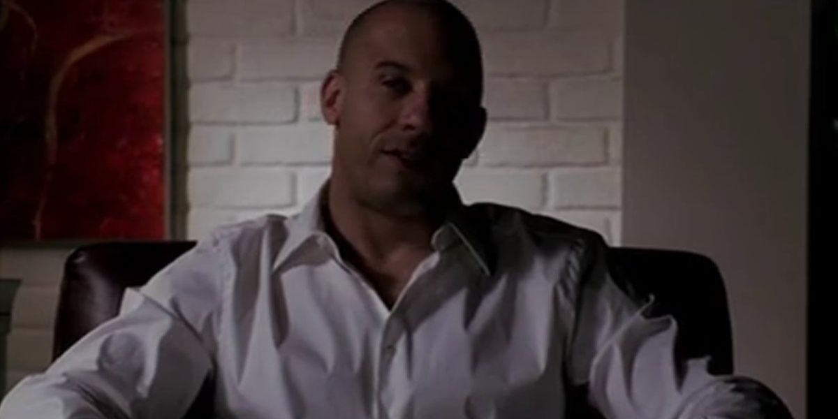 Vin Diesel sitting down and looking at the camera in a still from Los Bandoleros 