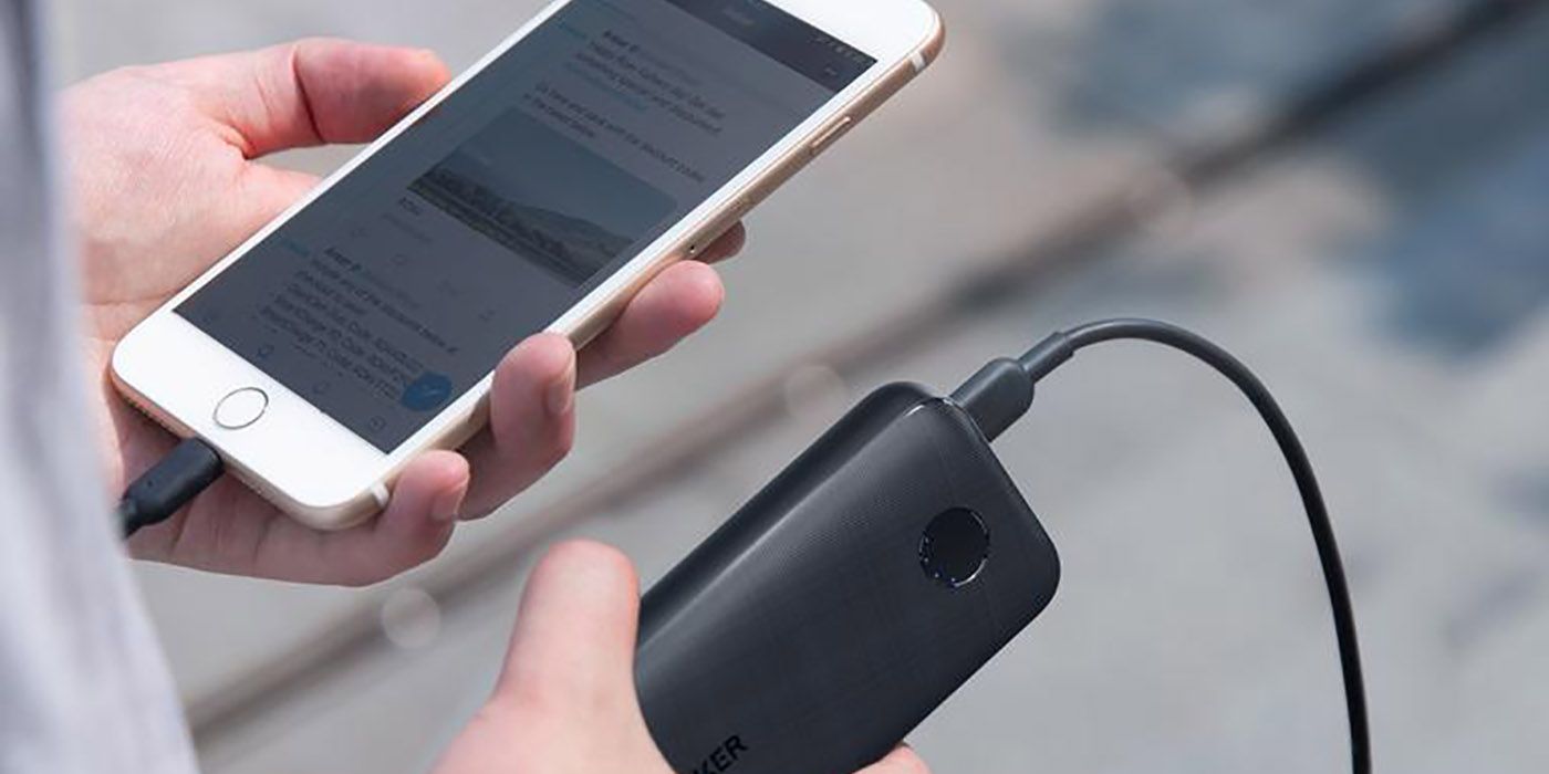 Anker redux portable charger in hand with a phone.