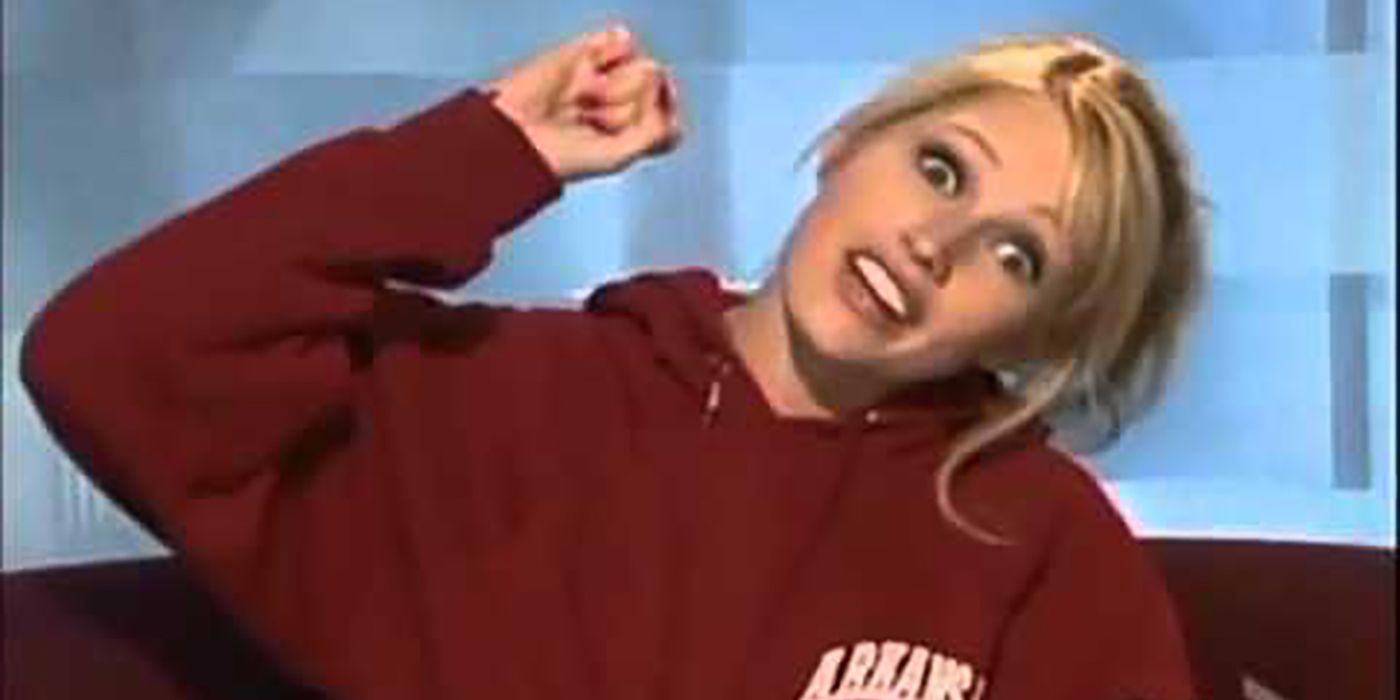 Britney from Big Brother in the diary room, holding her hand up in the air.