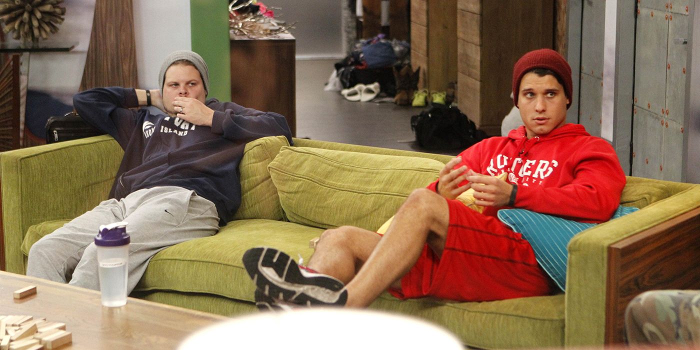 Derrick and Cody from The Hitmen alliance on Big Brother, sitting on opposite sides of the couch.