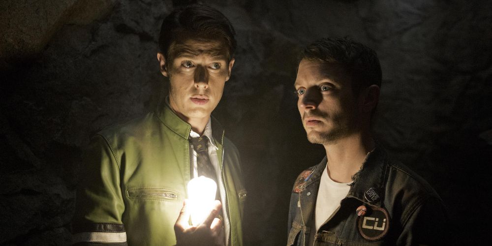 Dirk and Todd hold a light in a dark cave on Dirk Gently's Holistic Detective Agency