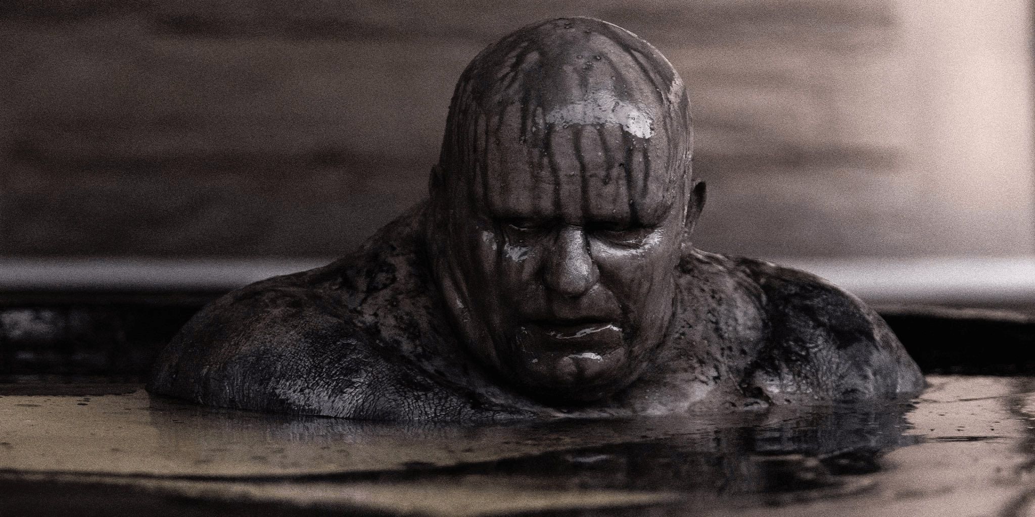 Baron Harkonnen emerges from a bath of black oil in Dune.
