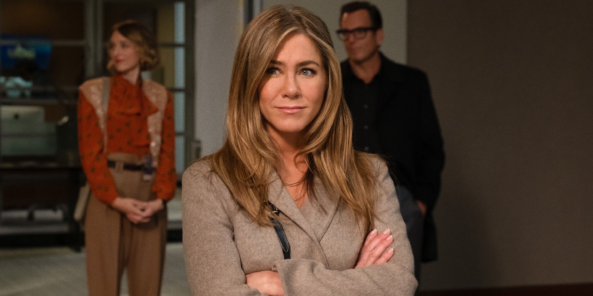 Alex Levy smiling with her arms crossed in the morning show season jennifer aniston as alex levy in the morning show season 2