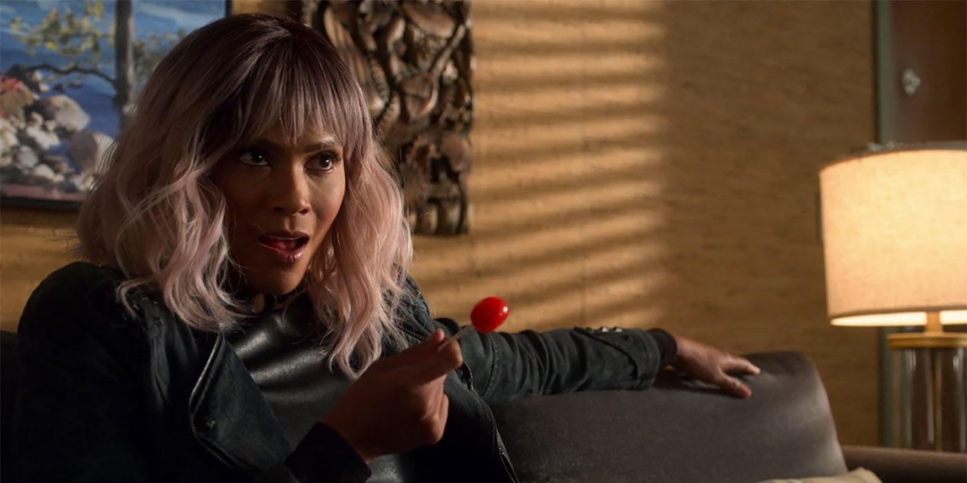 Maze from Lucifer sitting in Linda's office with a blonde bob haircut and red lollipop.