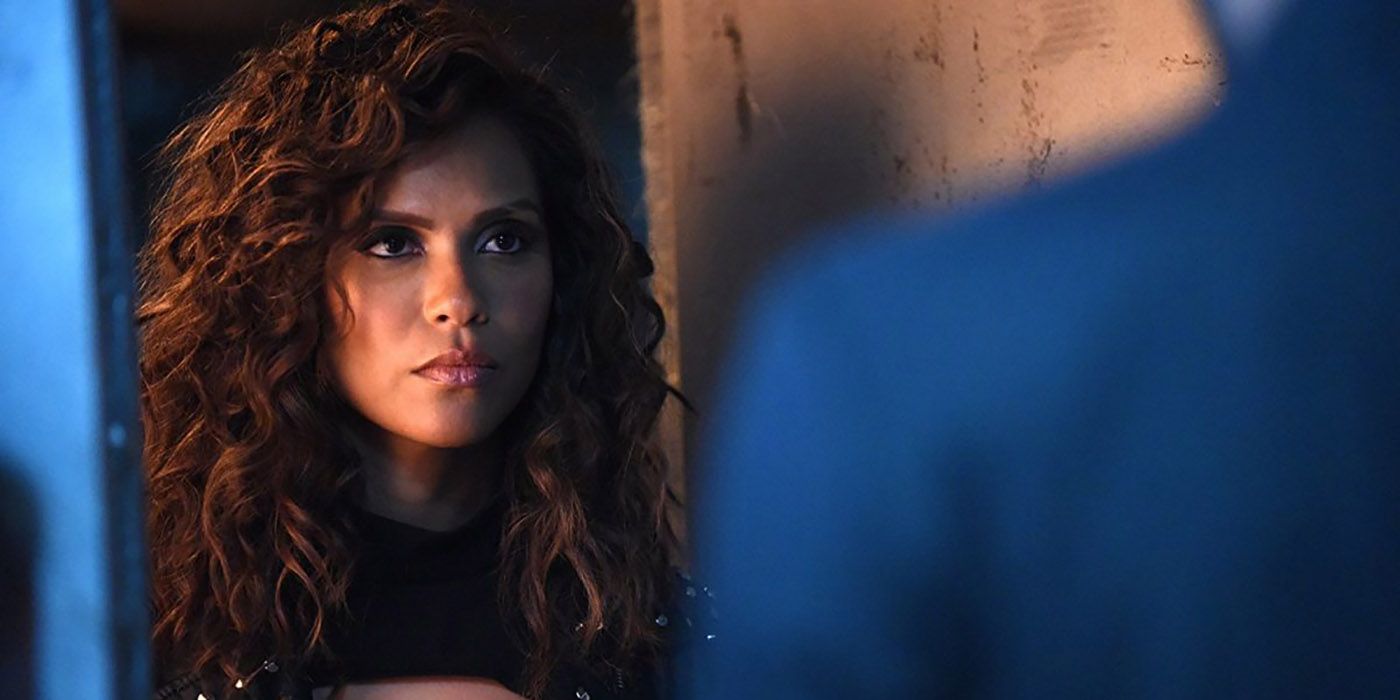 Maze from Lucifer standing at a door looking angry with curly hair.