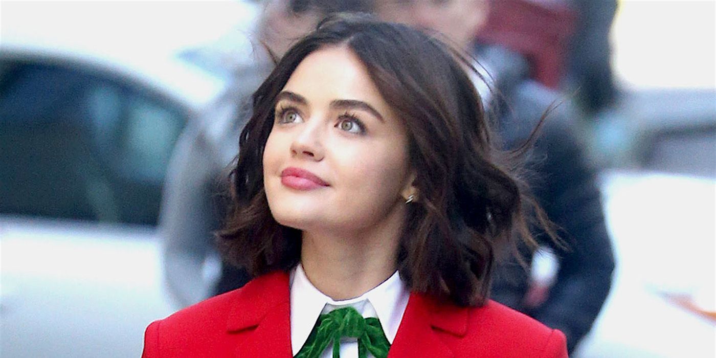 A close up of Lucy Hale as Katy Keene, bright red jacket and white shirt with a scarf tied around her neck.