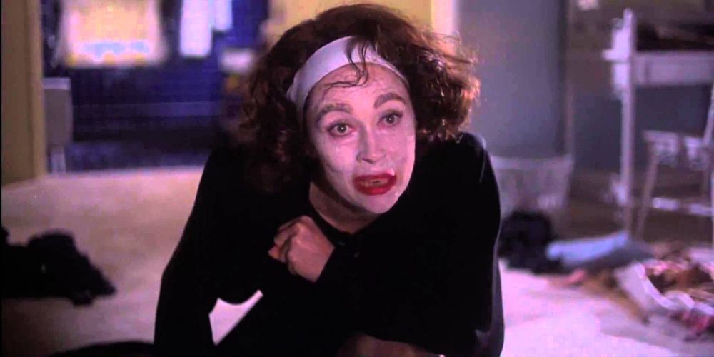 Joan falls to the floor in white makeup in Mommie Dearest
