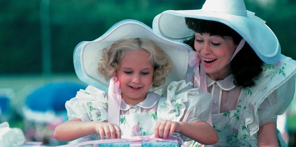 Joan helps Christina open birthday gifts in Mommie Dearest