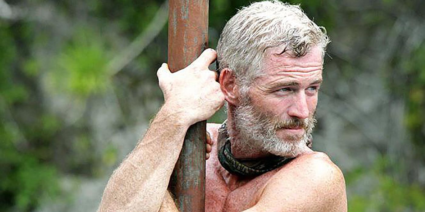 Tom Westman holding onto a pole in a competition on Survivor.