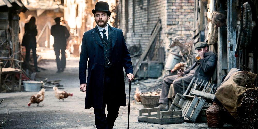 Lazslo walks down the street with a cane and top hat in The Alienist