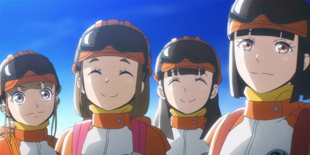 main characters of A Place Further Than the Universe smiling at the camera, wearing orange protective clothing