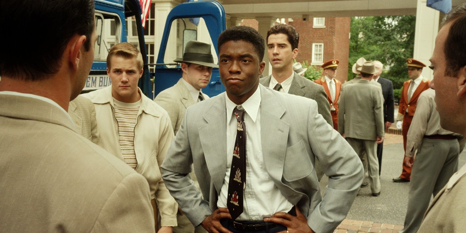 Chadwick Boseman, as Jackie Robinson, stands in front of teammates in the film 42