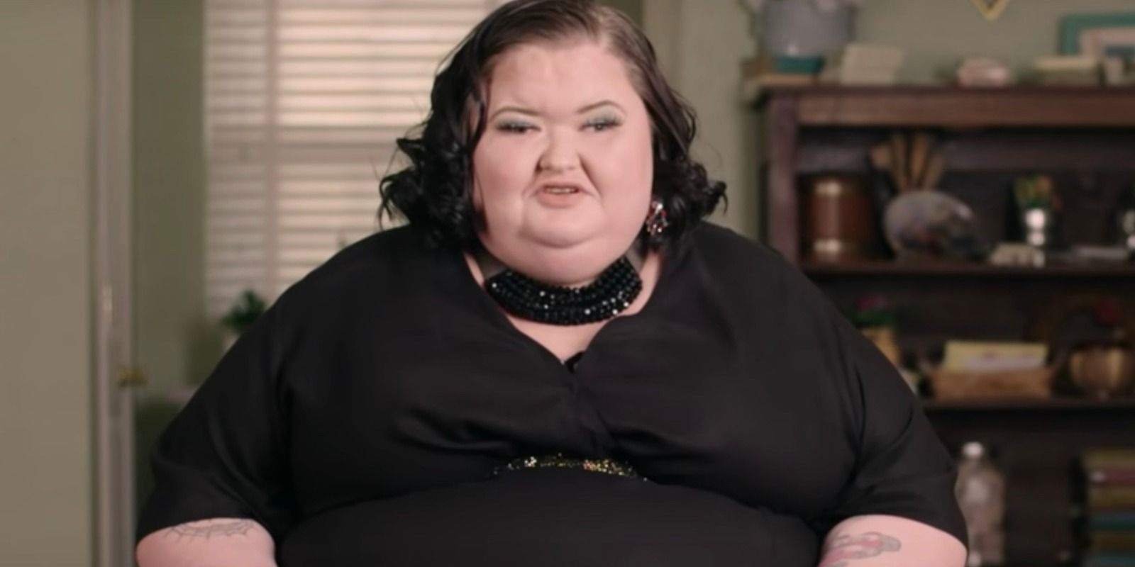 Amy Slaton porte une robe noire et un collier alors qu'elle parle à la caméra sur 1000-Lb Sisters