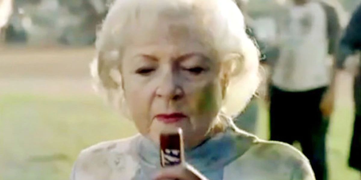 Betty White eats a Snickers bar on a football field in a commercial.