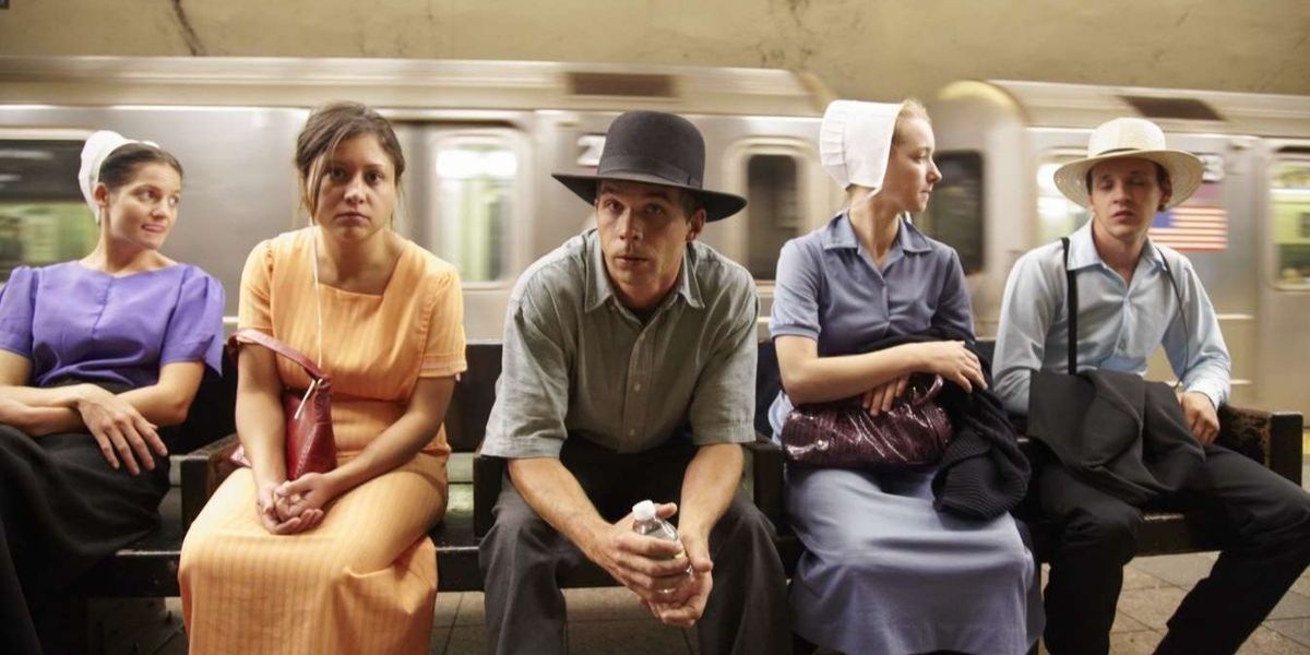 The cast of Breaking Amish sitting at a subway station