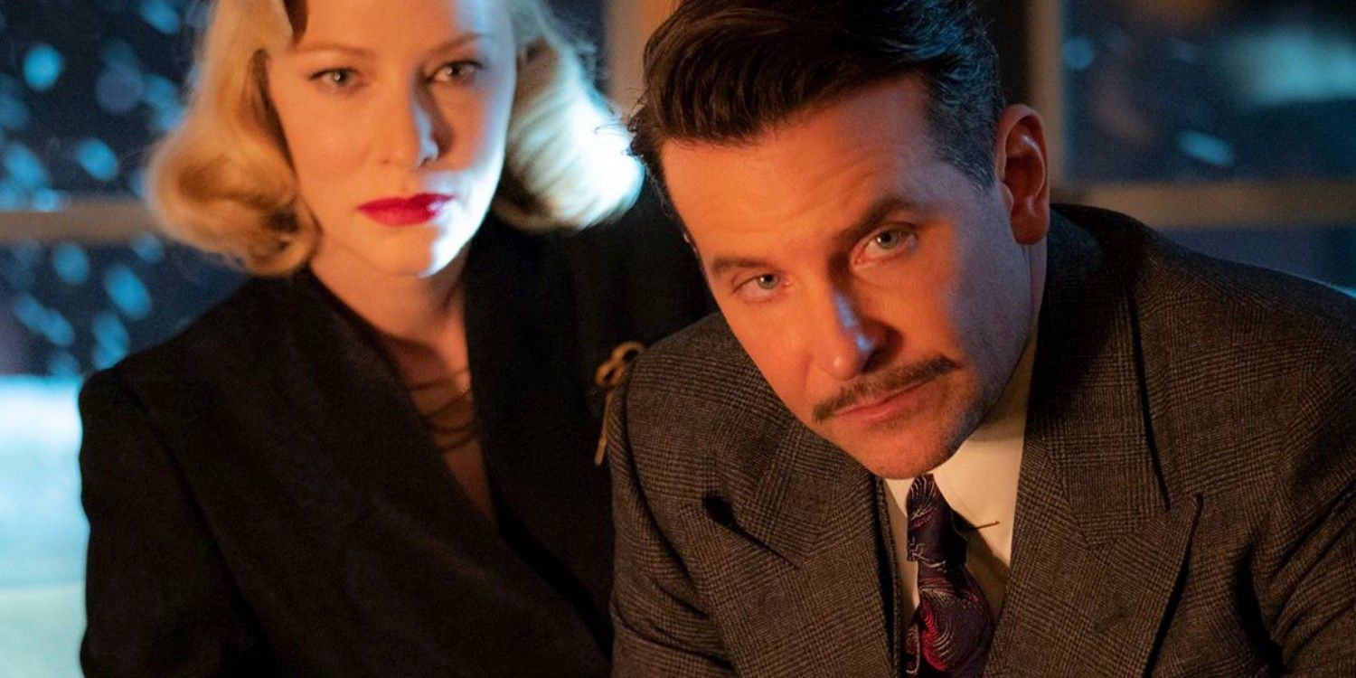 Cate Blanchett and Bradley Cooper sit together in Nightmare Alley
