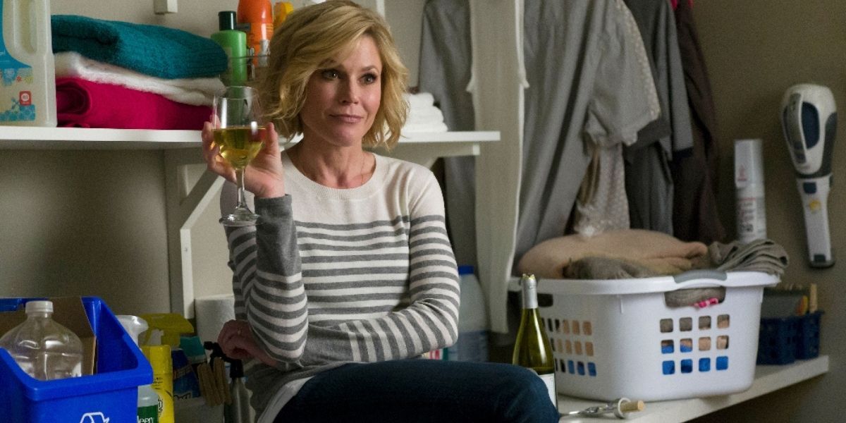 Claire sitting on the washing machine drinking wine in Modern Family