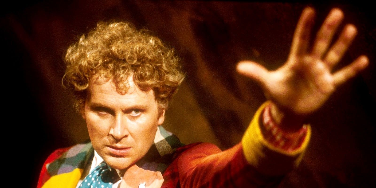 The Sixth Doctor with his arm reaching out in Doctor Who