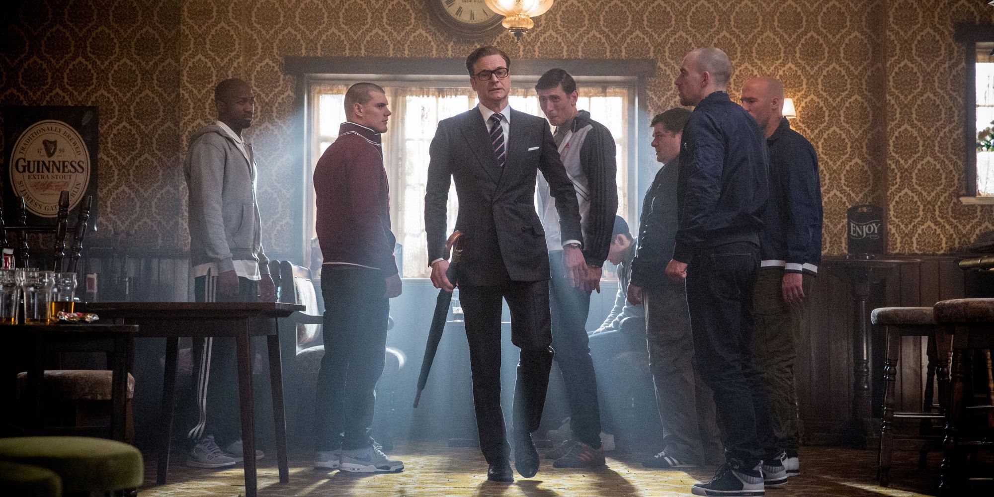 Colin Firth in the film Kingsman The Secret Service standing in a bar surrounded by people