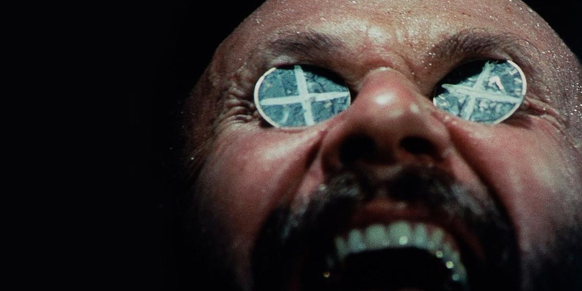 Doc Tydon with coins over his eyes in Wake in Fright