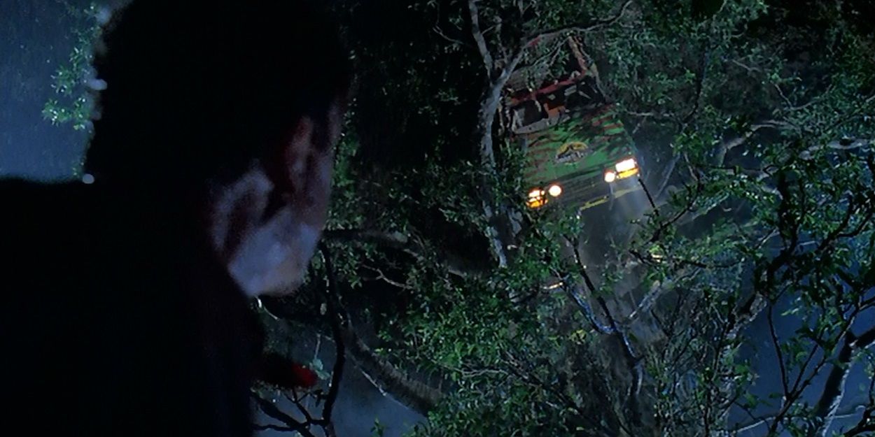 Dr Grant looks up at a car stuck in a tree in Jurassic Park