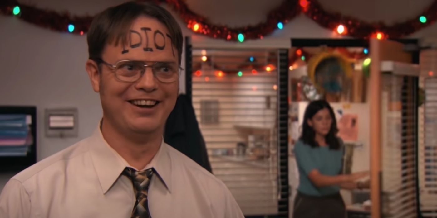 Dwight standing in front of the camera while Cathy walks through the door at a Christmas party on The Office