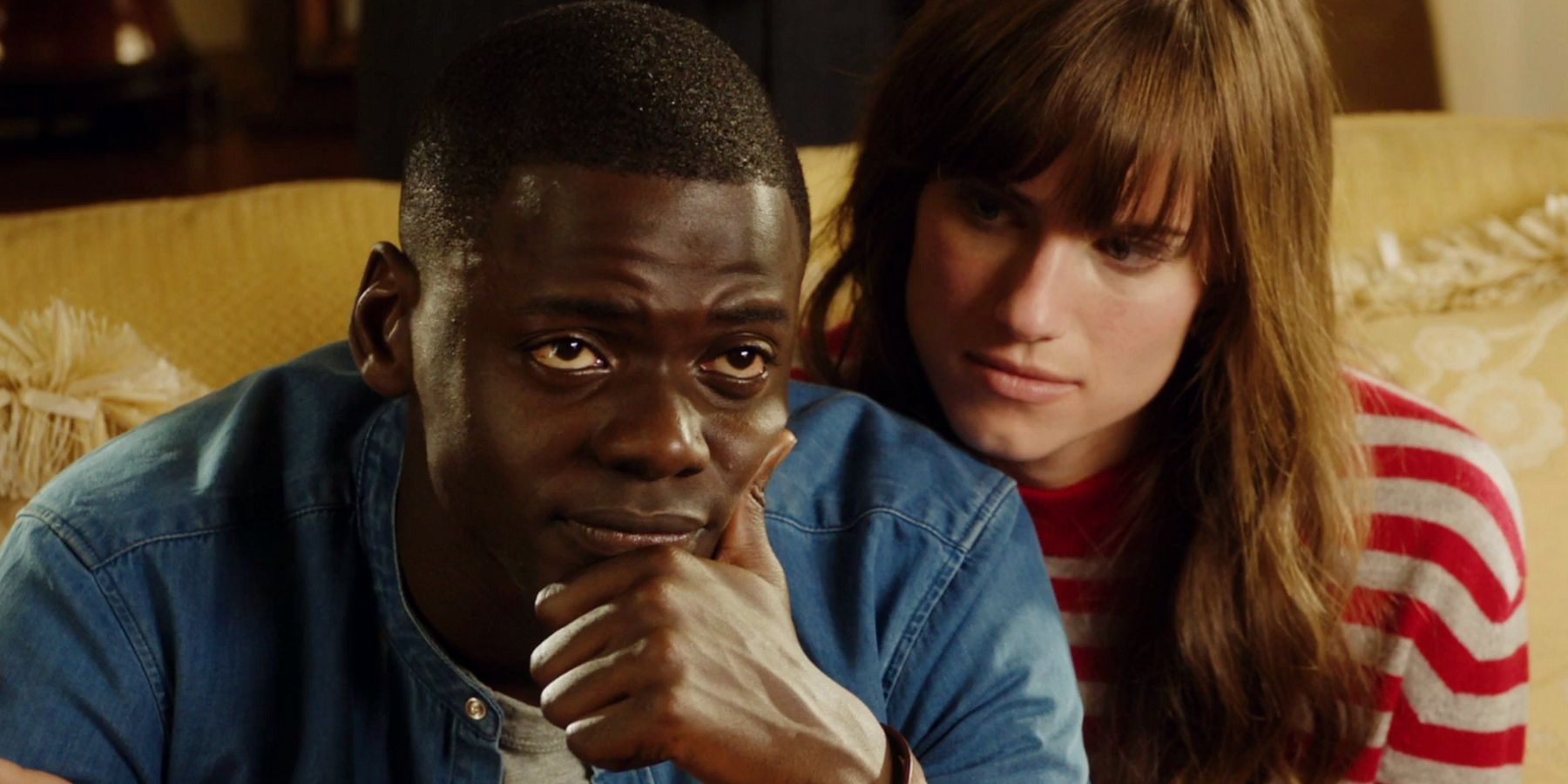 Get Out image with Daniel Kaluuya and Lake Bell sitting on a sofa.