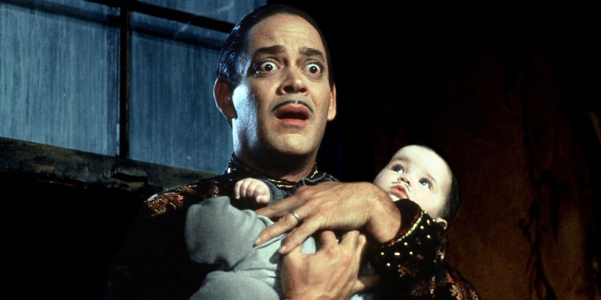 Gomez Addams from Addams Family Values looking shocked and holding his baby, Pubert
