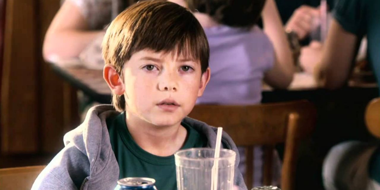 Griffin Gluck sits at a diner table and stares in Just Go With It.