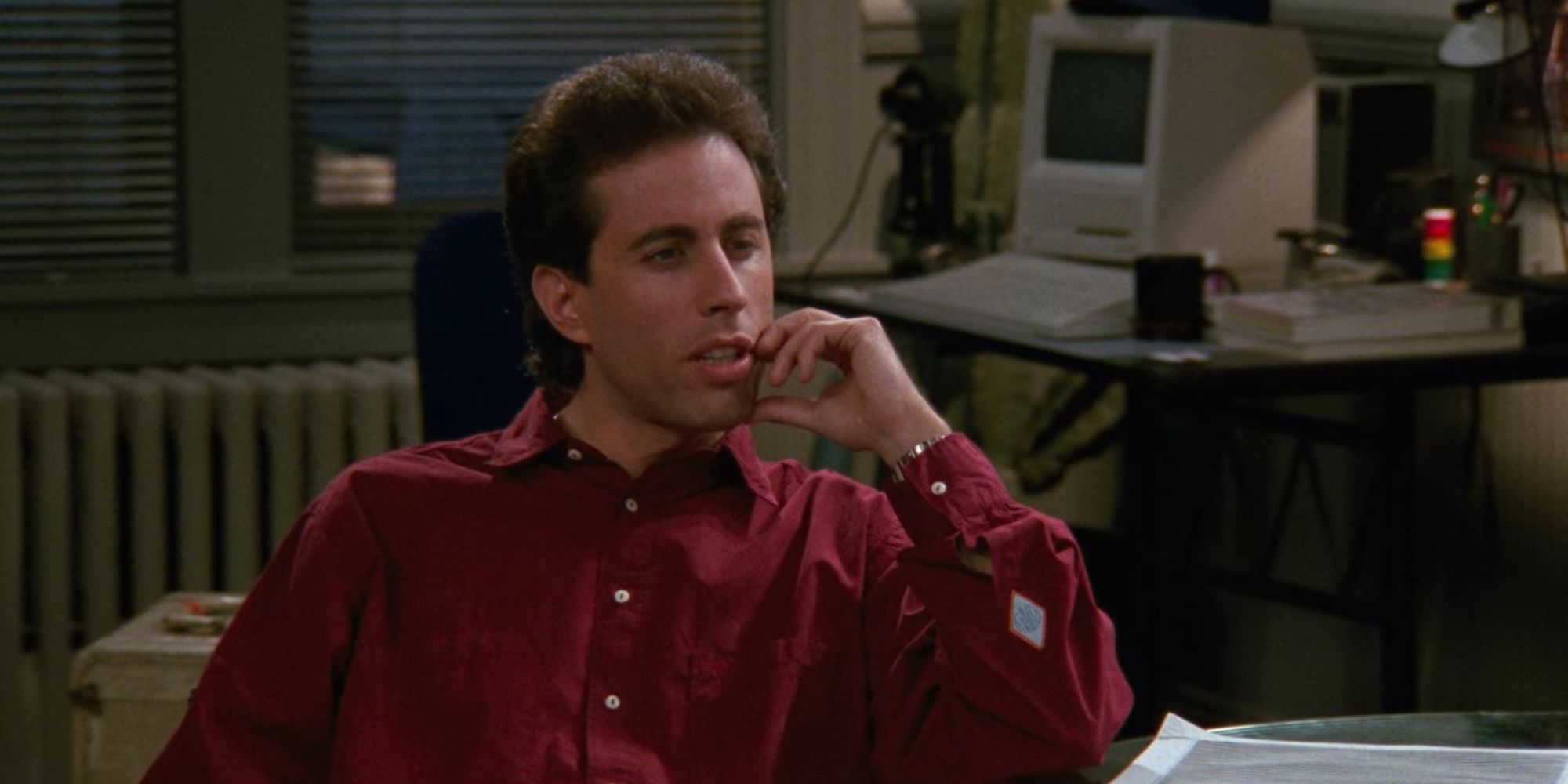 Jerry sitting on the couch in Seinfeld