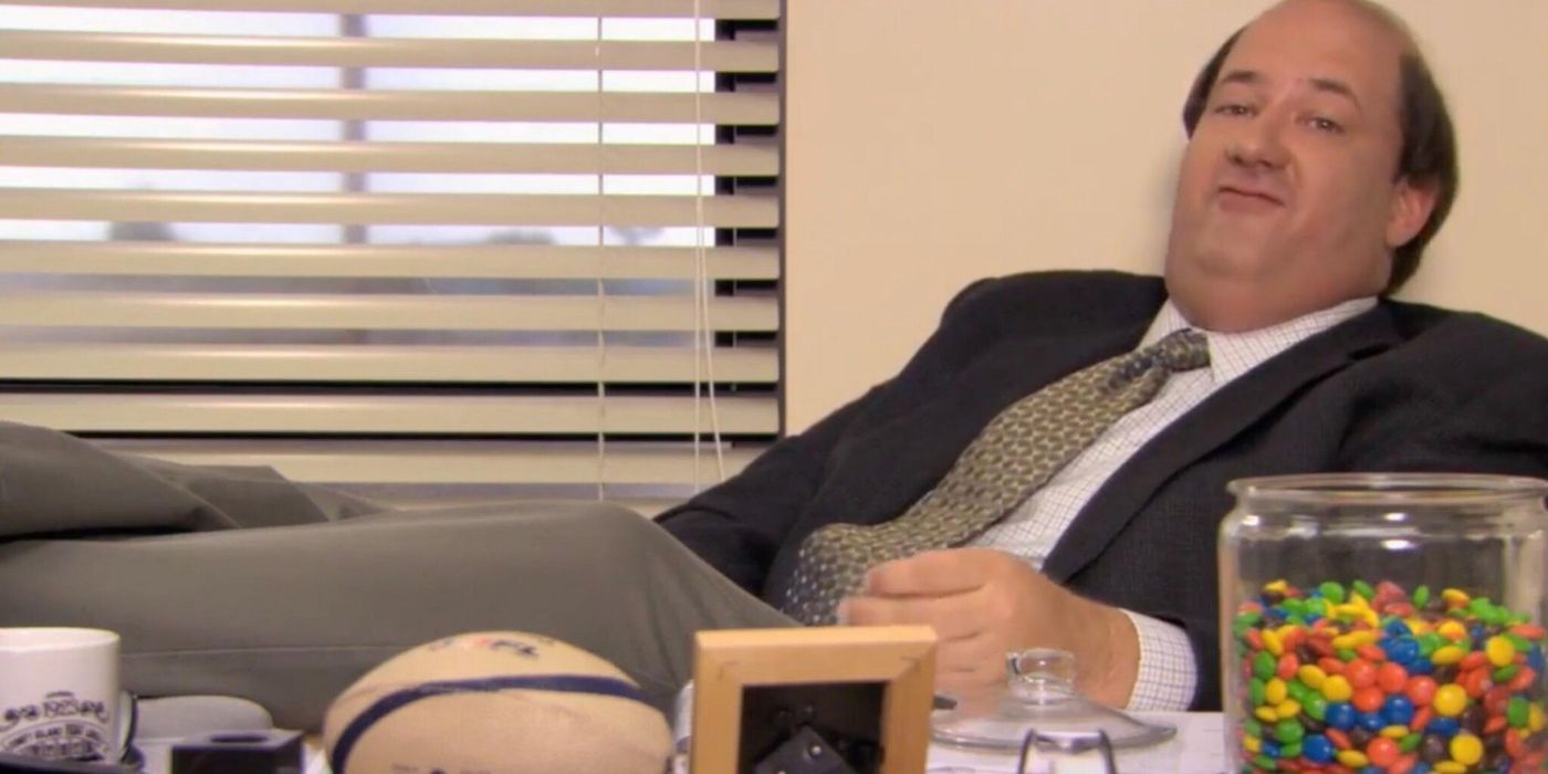 Kevin Malone sitting at Jim's desk while looking at the camera on The Office