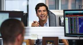 Hamish Linklater (Porter Collins) behind a computer monitor, smiling in The Big Short