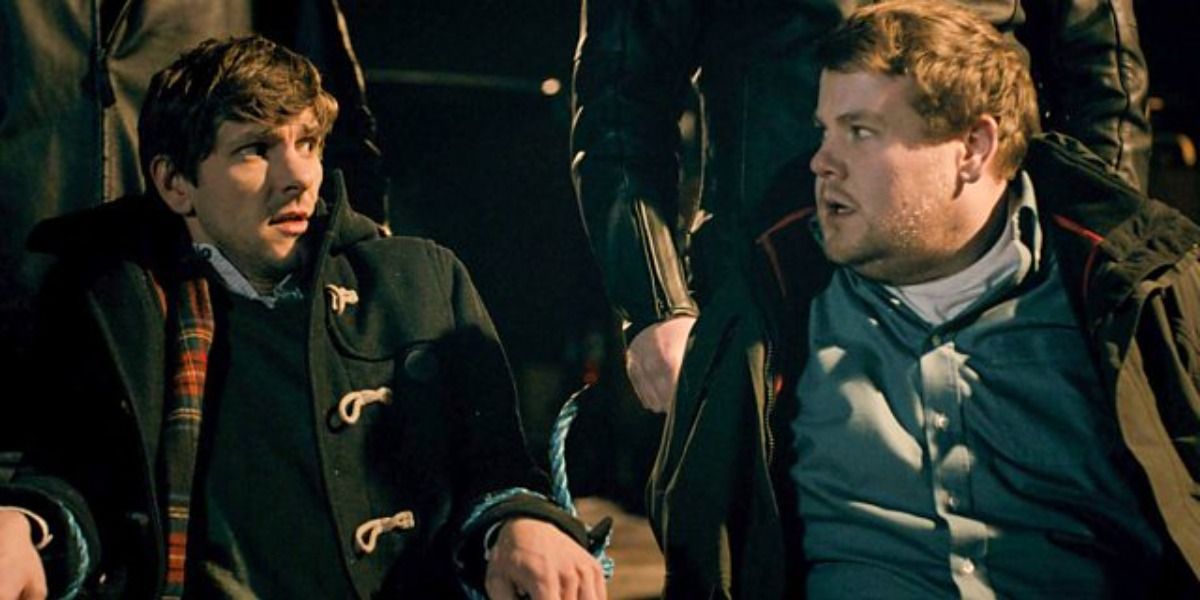 Mathew Baynton and James Corden in The Wrong Mans, surrounded by strong men