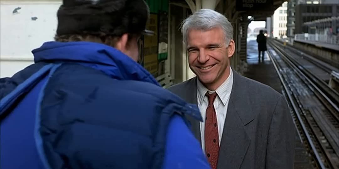 Neal smiles at Del in Planes, Trains and Automobiles