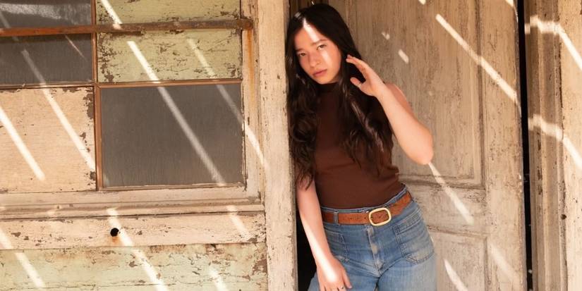 Mikey Madison leaning against a door frame in Once Upon a Time in Hollywood