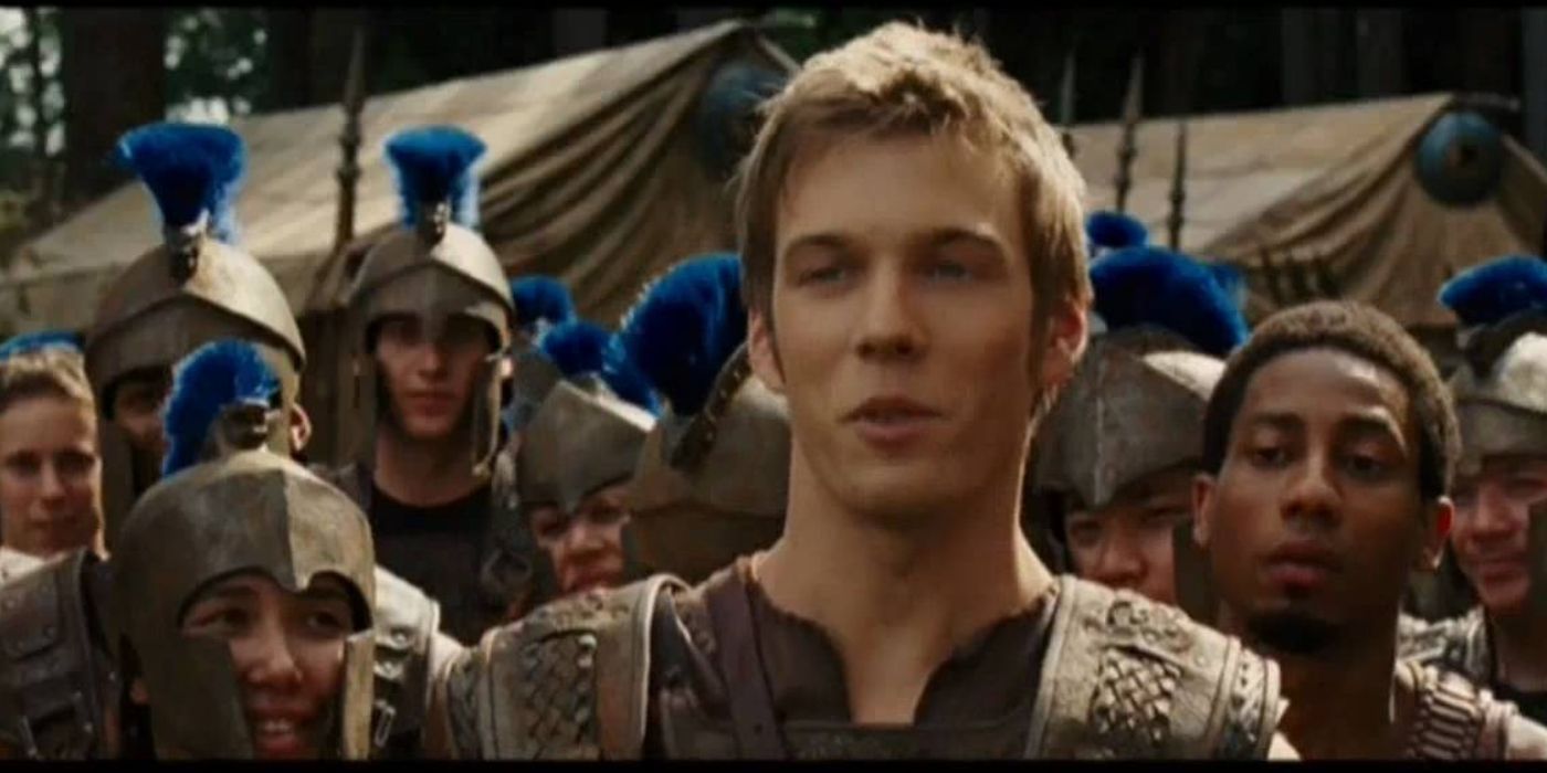Luke at the camp with others in battle gear behind him in Percy Jackson.