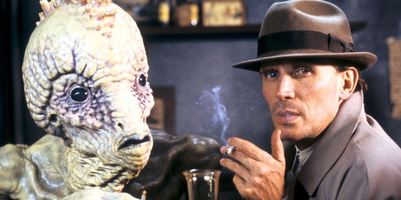 Peter Weller sitting with an alien in Naked Lunch.