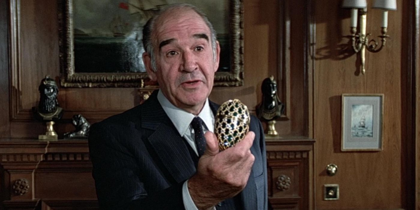 Robert Brown as M hold a crystal egg in front of him in the James Bond movies.