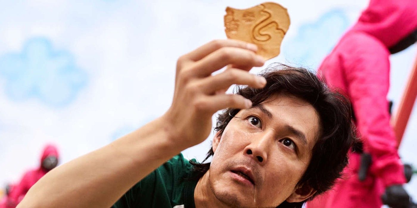 A contestant holding a piece of hardened honeycomb in Squid Game