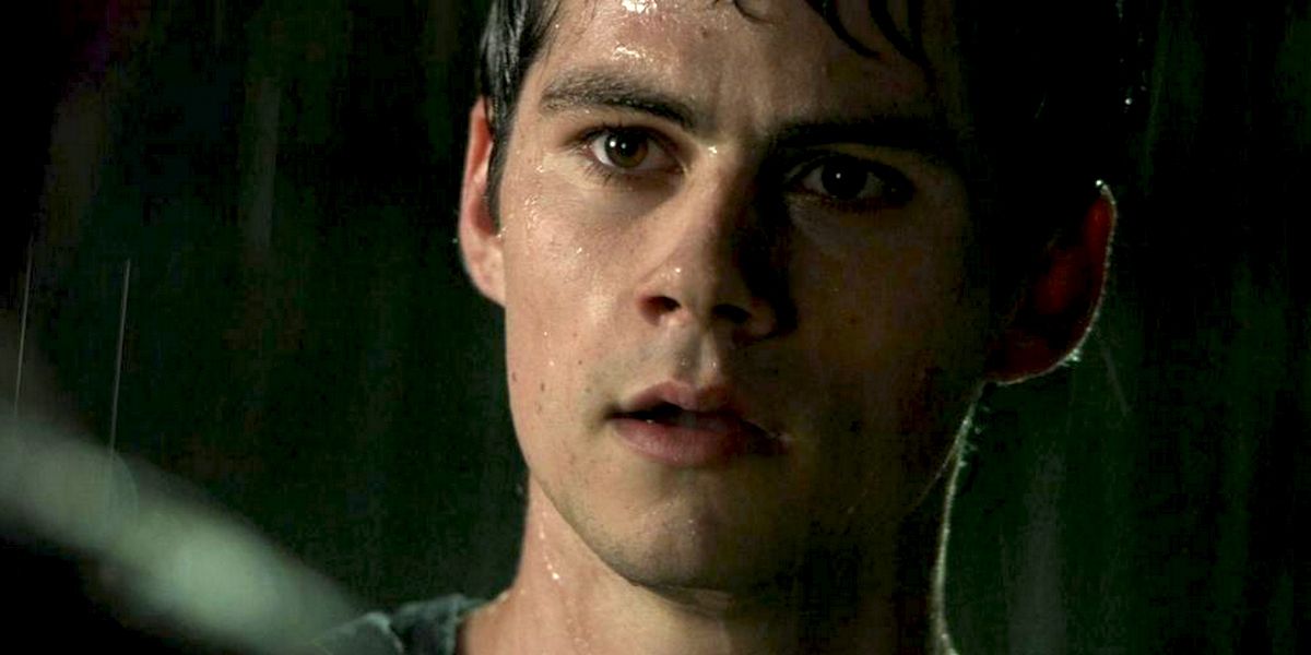 Stiles stands in the rain in Teen Wolf.